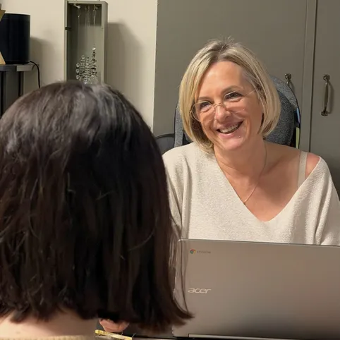 Véronique Tumson, souriante, en séance avec une personne de dos