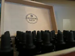 Pendule de radiesthésie au-dessus des flacons de fleurs de Bach
